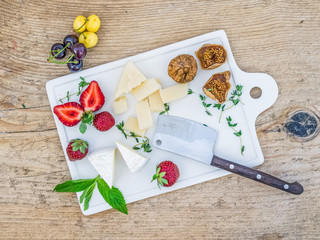 Cheese and fruit set on a rough wooden desk
