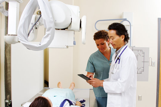 Radiologist and technician reviewing patients care