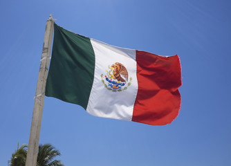 Naklejka na ściany i meble Mexican flag on blue sky.