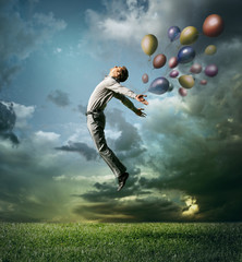 Man jumping up to Sky wit color bright balloon