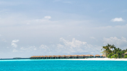 View of the coast of irufushi island with a bungalows, maldives
