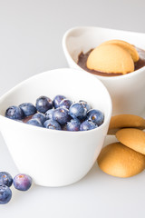 two cups of pudding with blueberries and biscuit