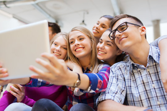group of smiling students with tablet pc