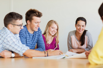 group of smiling students with blueprint