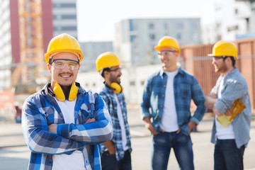 group of smiling builders in hardhats outdoors