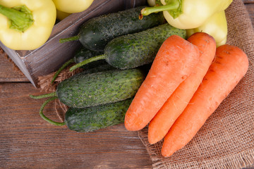 Yellow peppers in crate with cucumbers and carrots