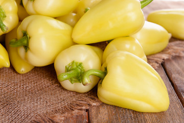 Yellow peppers on sackcloth on wooden table