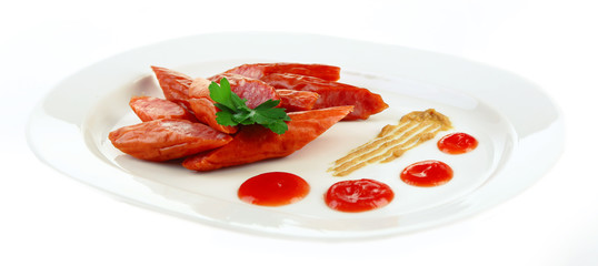 Smoked thin sausages and vegetables on plate, isolated on white