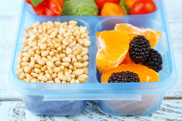 Tasty vegetarian food in plastic box on wooden table