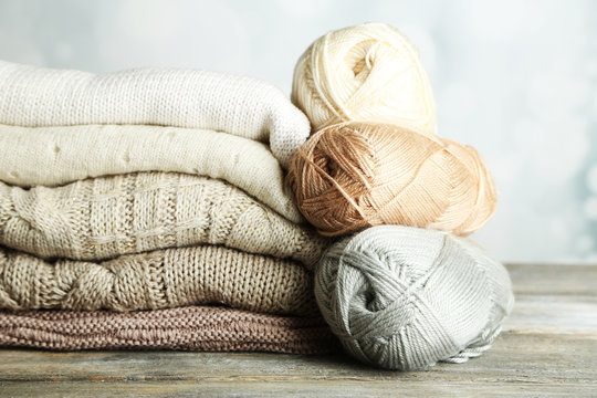 Knitting clothes and yarn on light background