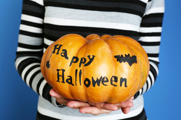 Young girl holding Halloween pumpkin, close-up,