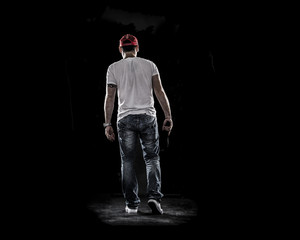 Boy Walking away , see from behind , handgun and cap