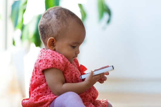 Portrait of little African American little girl holding a mobile