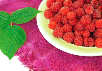 Ripe raspberries in a bowl on a towel