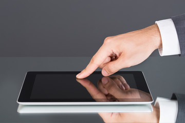 Hand pointing at tablet computer screen