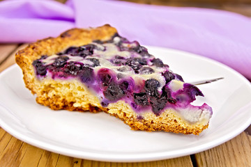 Pie with blueberries and spoon in plate on board