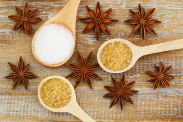 Fototapeta na wymiar White and brown sugar on wooden spoons and star anise