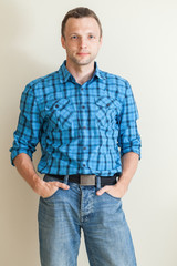Young Caucasian man in blue checkered shirt and jeans