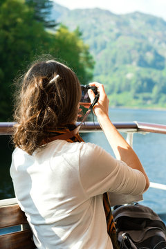 young female enjoying boat ride, taking photos, UK