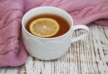 Cup of hot tea with lemon and scarf