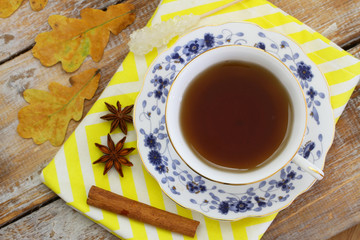 Obraz na płótnie Canvas Cup of tea, star anise, cinnamon, autumn leaves and chestnuts
