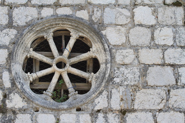 Round window in an old stone wall close-up