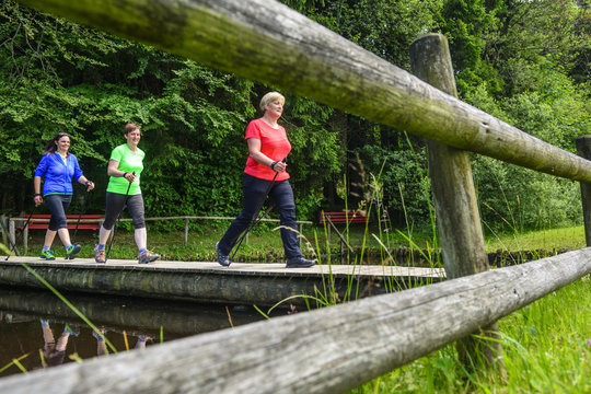 Drei Walkerinnen &uuml;berqueren Holzsteg