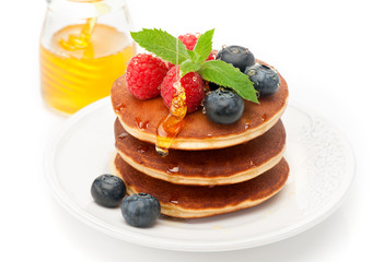 Delicious pancakes with honey and berries