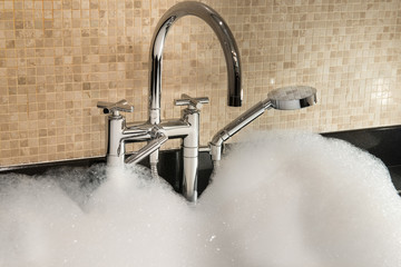 bathtub full of foam and chrome faucet