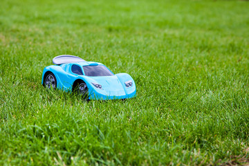 Blue toy sports car on green meadow