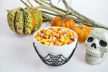 Bowl of candy corn in a Halloween theme on white background