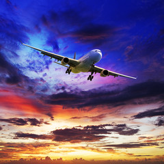 Naklejka premium Jet plane in a spectacular sunset sky