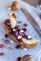 sandwich with vegetables, nuts and a pear on rye bread