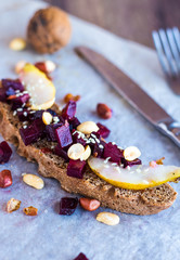 sandwich with vegetables, nuts and a pear on rye bread