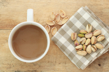 Pistachio nut and white coffee cup.