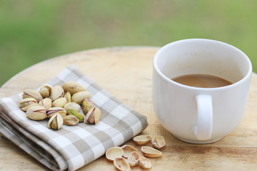 Pistachio nut and white coffee cup.