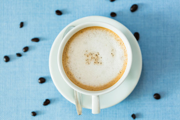 Cup of latte coffee on blue table