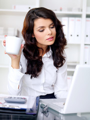 Young businesswoman working and drinking coffee