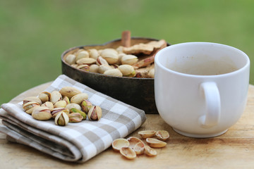 Pistachio nut and white coffee cup.