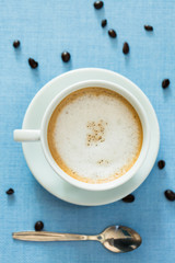 Cup of latte coffee on blue table