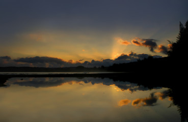 Mist rise over small bay on the Island of Kauai.  Sunrise is reflected in the still, calm waters.