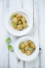 Italian ravioli with basil pesto in two glass plates, above view