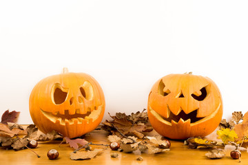 Halloween pumpkins with autumn leaves isolated on white