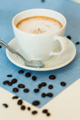 Cup of latte coffee on blue table