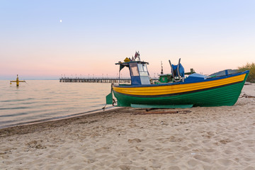 Naklejka na ściany i meble Baltic beach with fishing boat at sunset, Poland