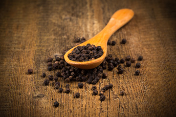 black pepper on wooden spoon