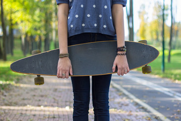 fashion young woman posing  with a longboard