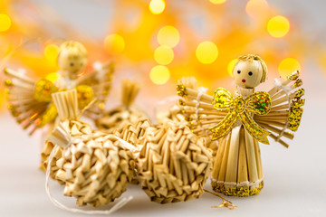six straw christmas balls and two angels on white background wit