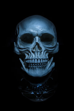 Spooky skull with reflection on black background