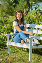 Cute girl teenager sitting on white bench